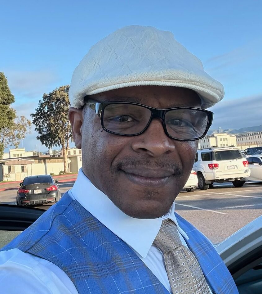 Formerly incarcerated man smiling, standing outside with a Bible in hand.